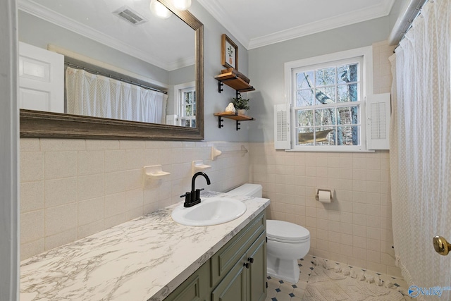 bathroom featuring toilet, visible vents, vanity, tile walls, and ornamental molding