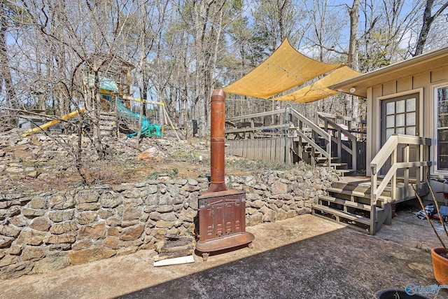 view of yard featuring a deck, a patio, a playground, and stairs