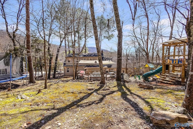 view of yard with a trampoline and a playground