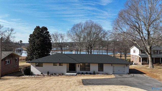 view of front of property with a garage and a water view