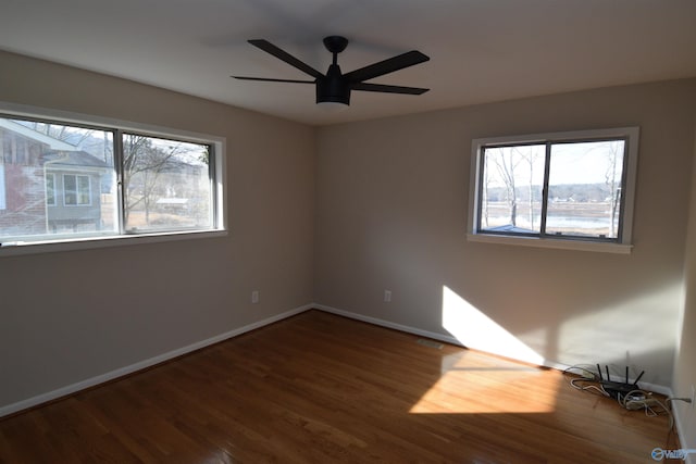 unfurnished room with dark wood-type flooring and ceiling fan