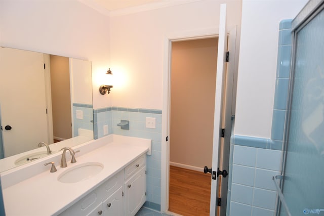 bathroom with tile walls, vanity, ornamental molding, and hardwood / wood-style floors