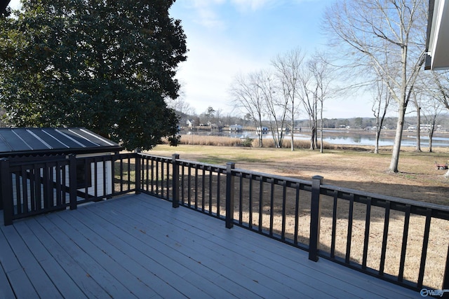 deck with a water view and a lawn