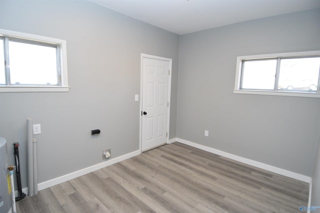 clothes washing area with a wealth of natural light and light hardwood / wood-style floors