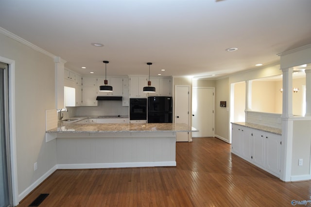 kitchen with hanging light fixtures, kitchen peninsula, white cabinets, and black appliances