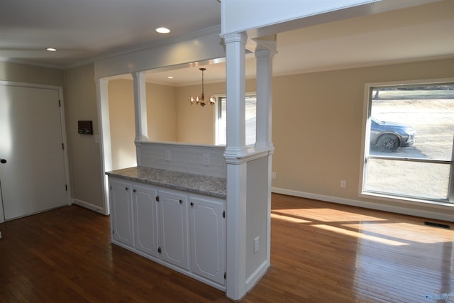 kitchen with white cabinetry, crown molding, dark hardwood / wood-style flooring, and ornate columns