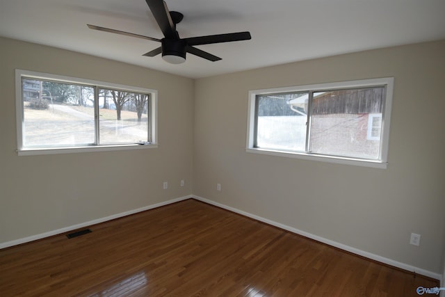 unfurnished room with ceiling fan and dark hardwood / wood-style flooring