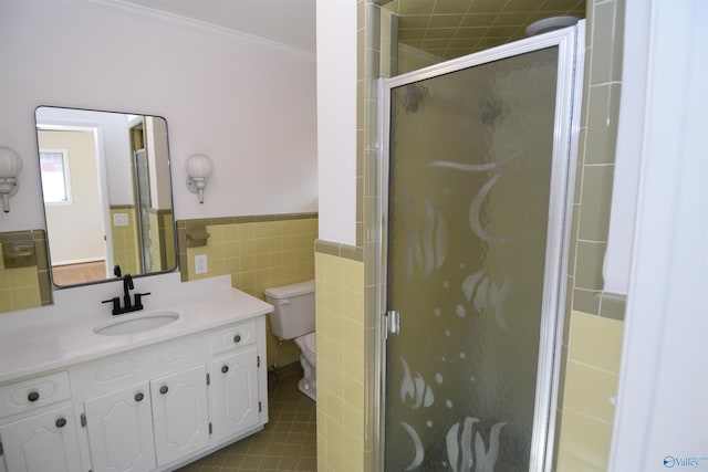 bathroom featuring crown molding, vanity, a shower with door, and tile walls