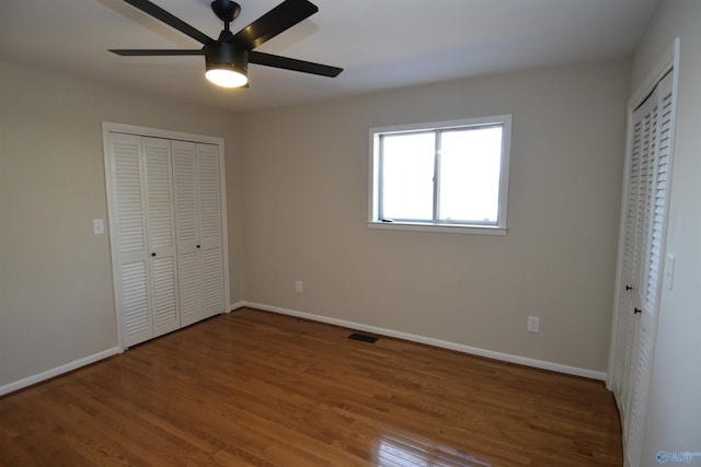 unfurnished bedroom with ceiling fan and wood-type flooring