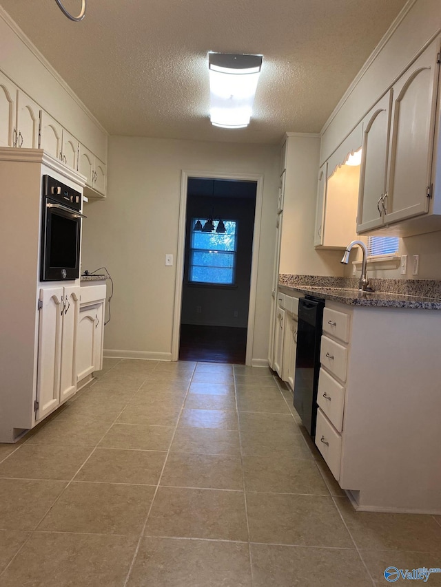 kitchen with light tile patterned floors, ornamental molding, white cabinetry, and black appliances