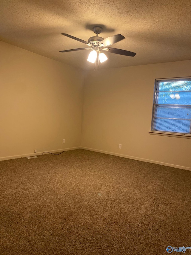 carpeted spare room with a textured ceiling and ceiling fan