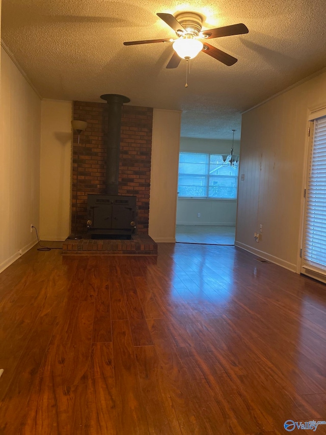 unfurnished living room with a textured ceiling, dark hardwood / wood-style floors, ceiling fan, and a wood stove