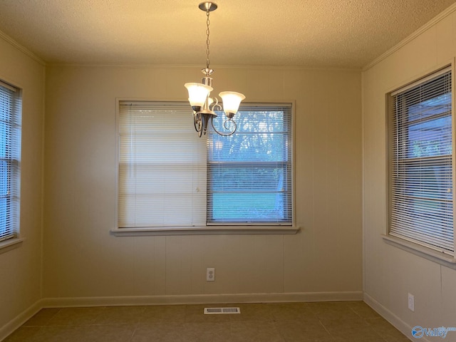 unfurnished dining area with an inviting chandelier, a textured ceiling, and a healthy amount of sunlight