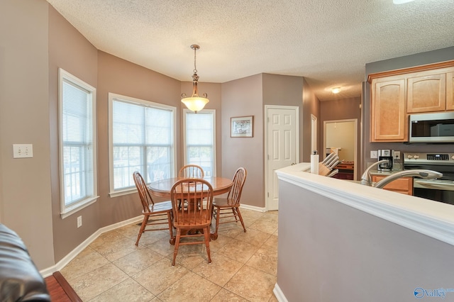 dining area featuring light tile patterned flooring, baseboards, and a textured ceiling