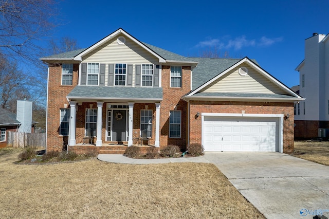 view of front facade with a porch, driveway, brick siding, and a garage