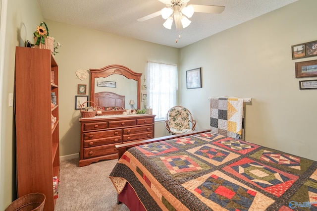 bedroom with a ceiling fan, carpet floors, and a textured ceiling