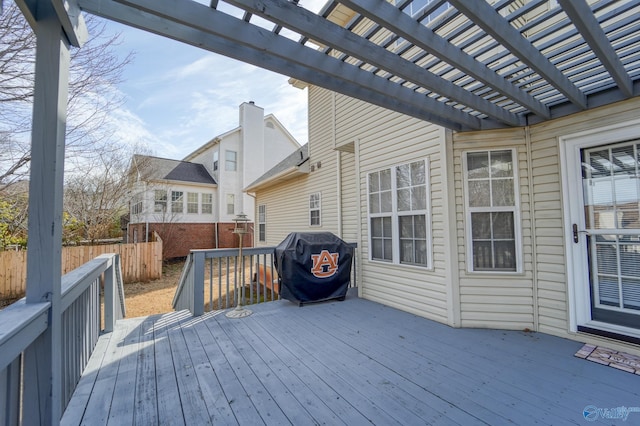 deck featuring a grill, a pergola, and fence