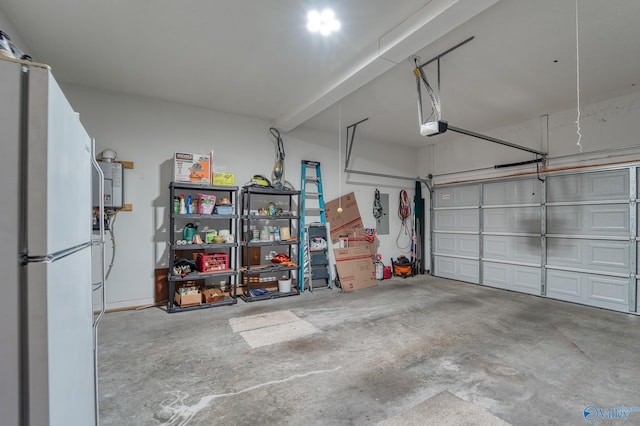 garage featuring a garage door opener, water heater, and freestanding refrigerator