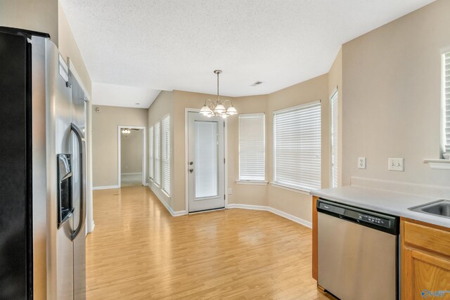 123 Otter Trl, Huntsville, AL 35824 - kitchen featuring stainless steel appliances, a chandelier, light wood finished floors, light countertops, and pendant lighting