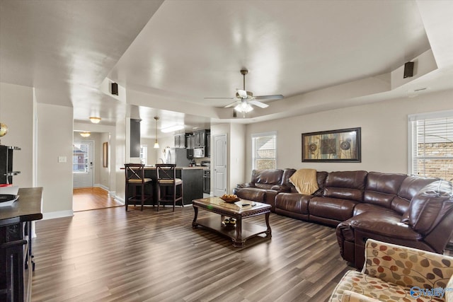 living room featuring ceiling fan and dark hardwood / wood-style flooring