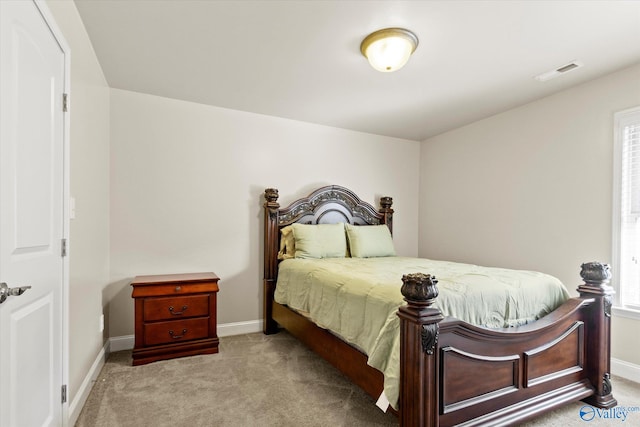 bedroom with light carpet and multiple windows