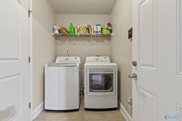 clothes washing area featuring washer and dryer and light tile patterned floors