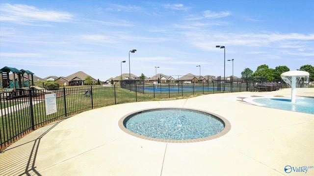 view of swimming pool featuring a hot tub and a patio area