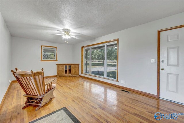 sitting room featuring hardwood / wood-style floors, a textured ceiling, and ceiling fan