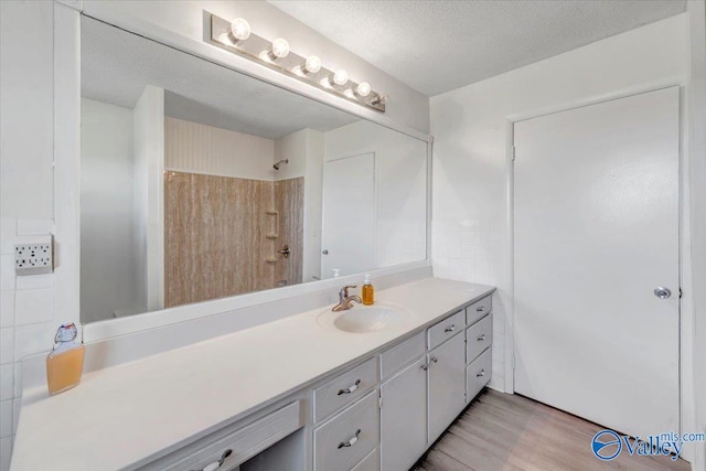 bathroom featuring vanity, a textured ceiling, and wood-type flooring