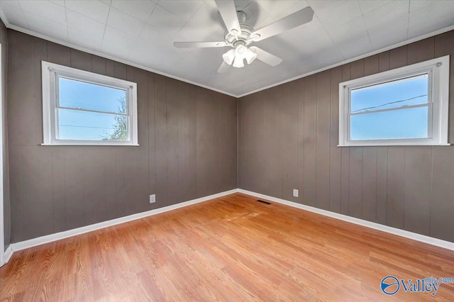 empty room featuring light hardwood / wood-style flooring and wooden walls