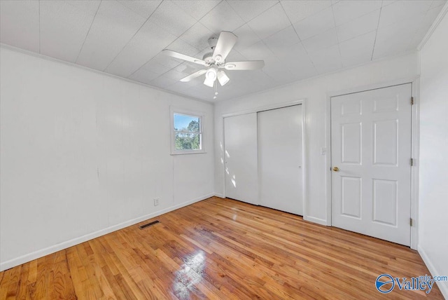 unfurnished bedroom featuring ceiling fan, ornamental molding, and light wood-type flooring