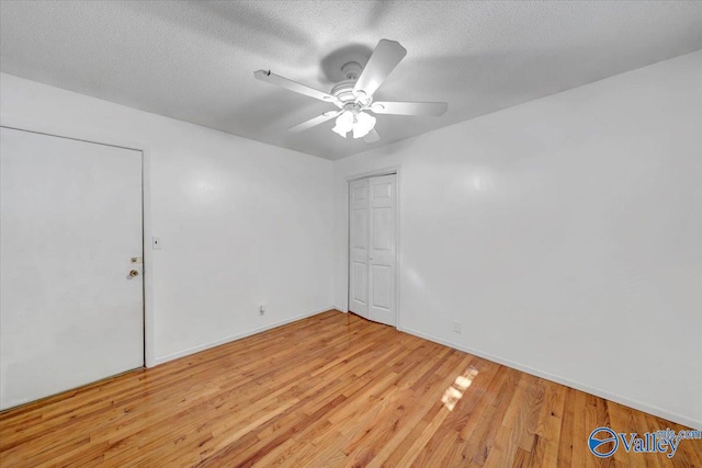 unfurnished room with light hardwood / wood-style flooring, a textured ceiling, and ceiling fan