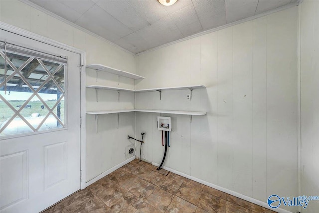 washroom with hookup for a washing machine, crown molding, and wood walls