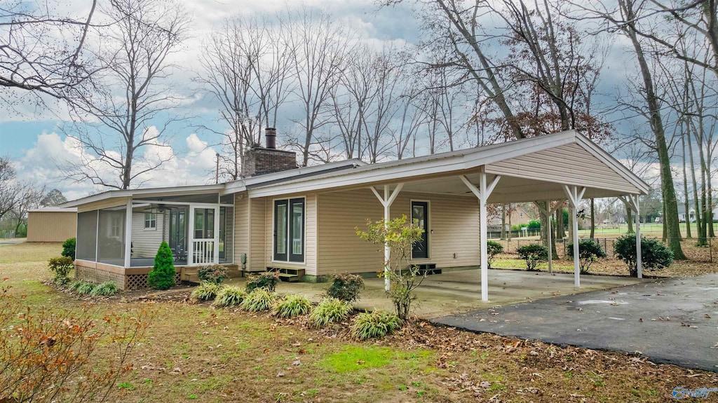 back of property with a carport and a sunroom