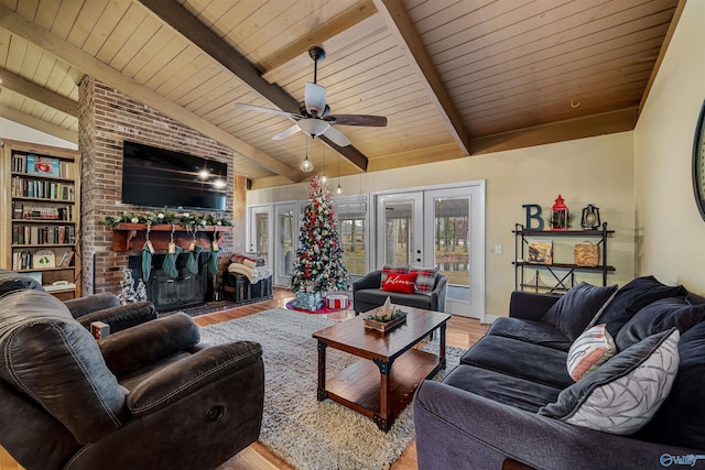 living room featuring a fireplace, lofted ceiling with beams, light wood-type flooring, wood ceiling, and french doors