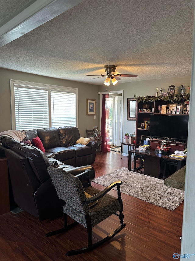 living room featuring ceiling fan, a textured ceiling, and hardwood / wood-style floors