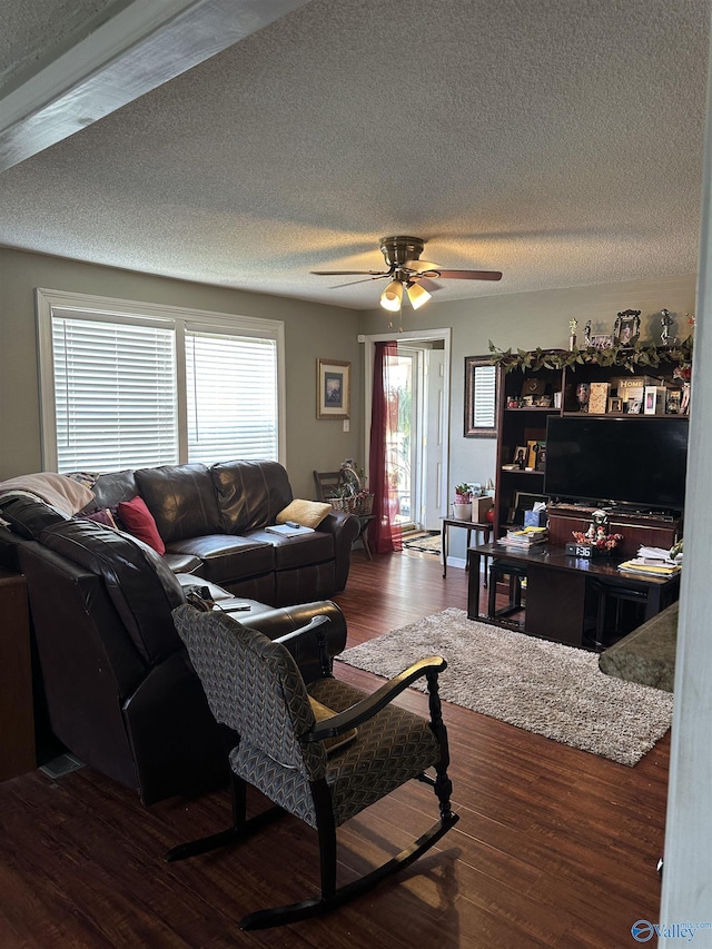 living room with a textured ceiling, wood finished floors, and a ceiling fan