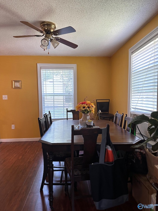 dining space featuring dark wood-style floors, ceiling fan, baseboards, and a textured ceiling