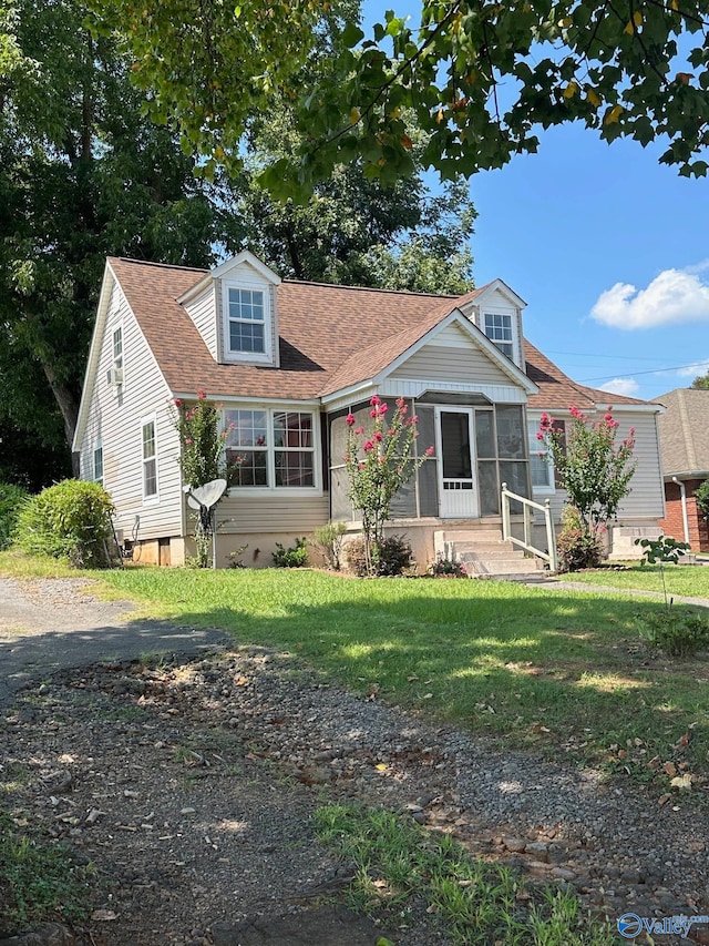 view of front of property featuring a sunroom and a front lawn