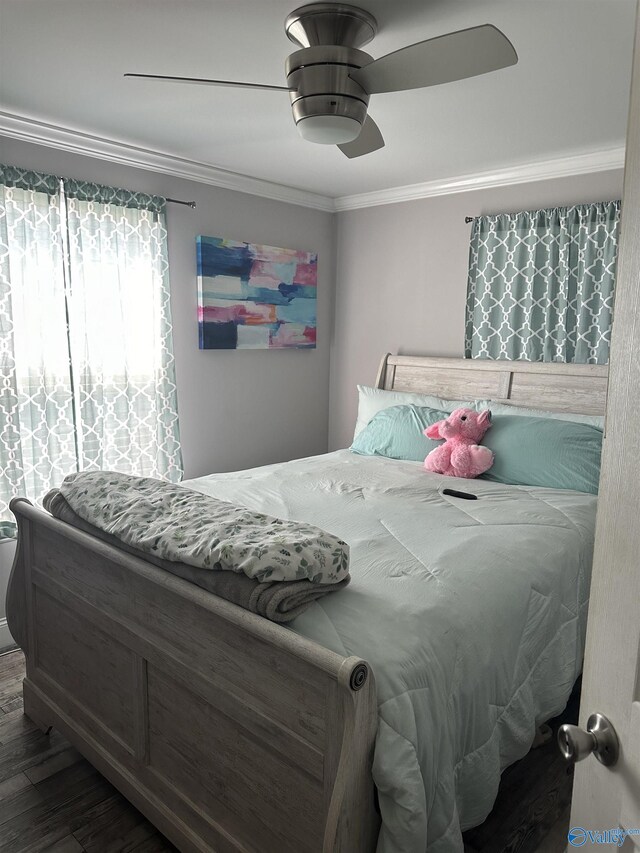 bedroom featuring hardwood / wood-style floors, ornamental molding, and ceiling fan