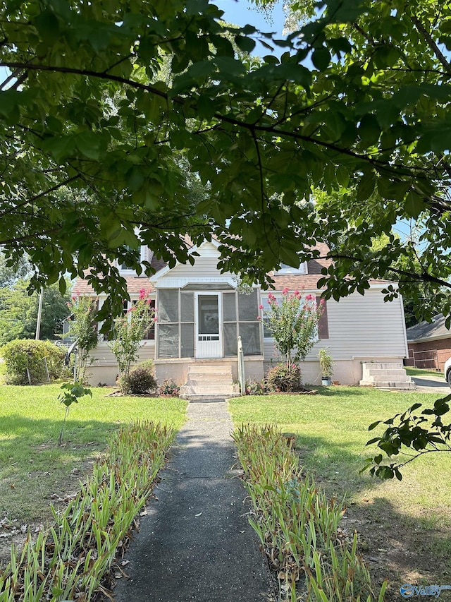 view of front of property with a sunroom and a front yard