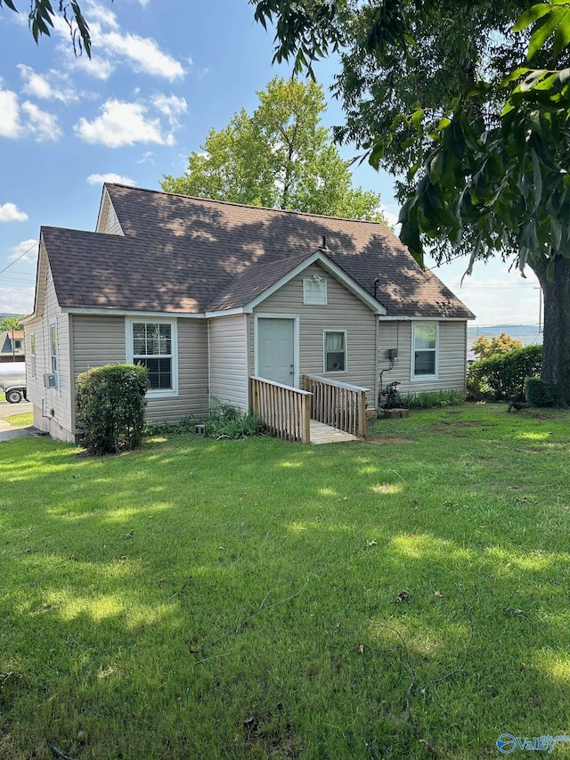 view of front of property featuring roof with shingles and a front yard