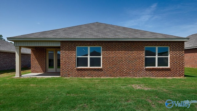 rear view of house with a lawn and a patio