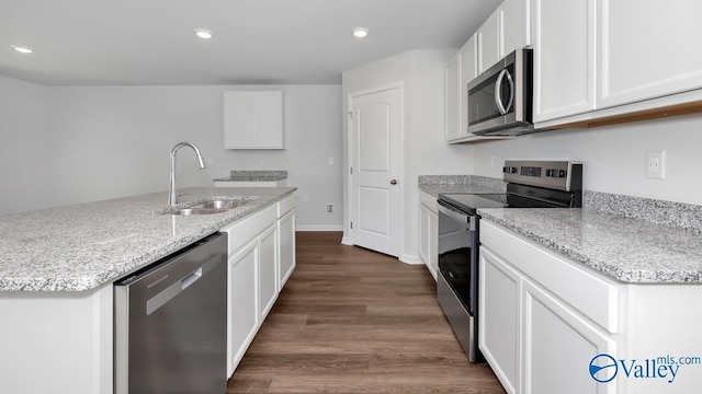 kitchen featuring appliances with stainless steel finishes, white cabinetry, sink, dark hardwood / wood-style flooring, and a kitchen island with sink