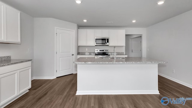 kitchen featuring sink, white cabinetry, a center island with sink, appliances with stainless steel finishes, and light stone countertops