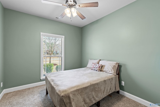 carpeted bedroom with visible vents, baseboards, and ceiling fan