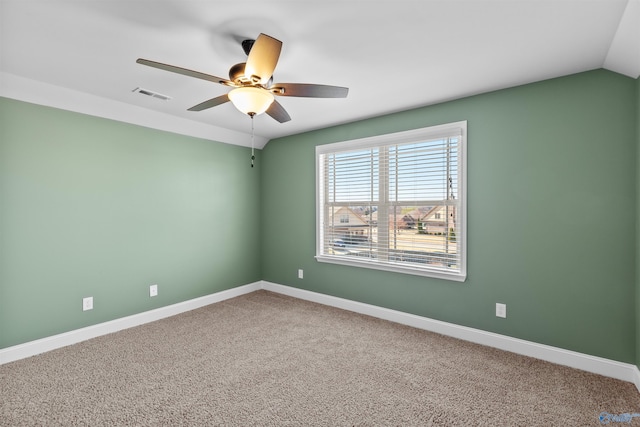 carpeted spare room featuring visible vents, ceiling fan, baseboards, and lofted ceiling