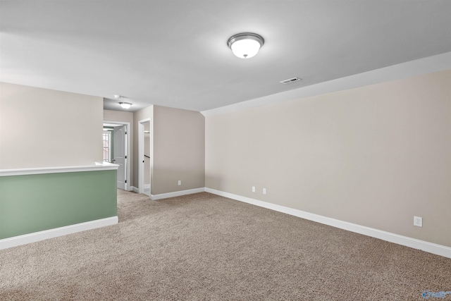 spare room with visible vents, light colored carpet, and baseboards