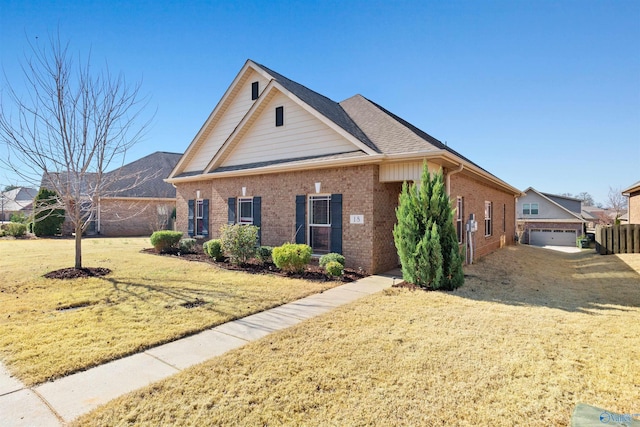 view of front of home with brick siding, an outdoor structure, a front lawn, and a shingled roof