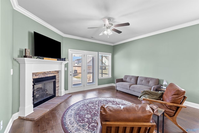 living room with baseboards, wood-type flooring, a ceiling fan, and crown molding